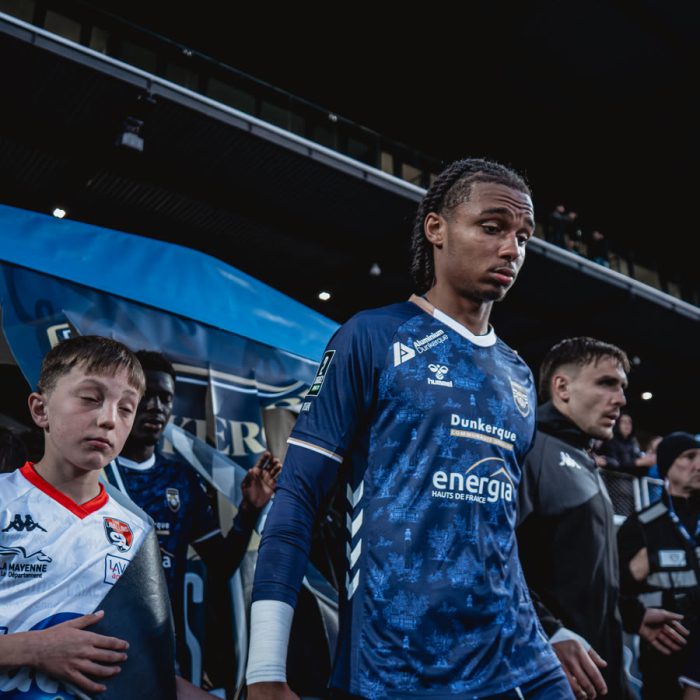 Un joueur de l’USL Dunkerque entre sur le terrain accompagne d’un enfant