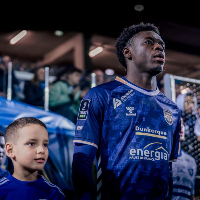 Un joueur de l’USL Dunkerque aux cotes d’un jeune supporter avant le match